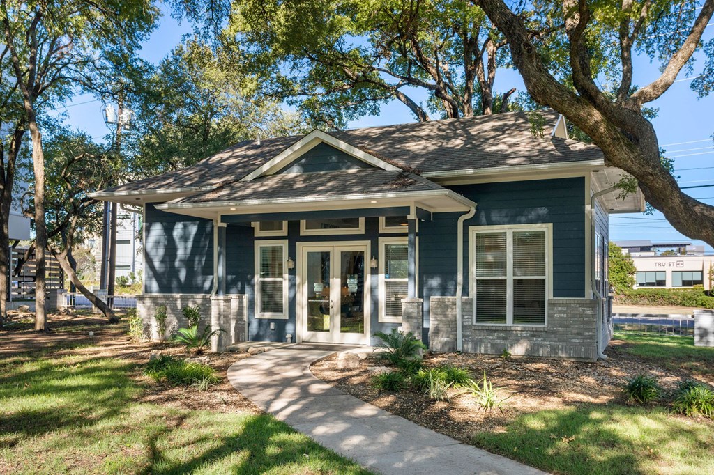 a small house with a sidewalk and trees in front of it a small house with a sidewalk and trees in front of it at South Lamar Village, Austin, Texas